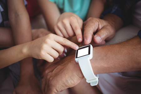 Close-up of family pointing at smart watchの写真素材
