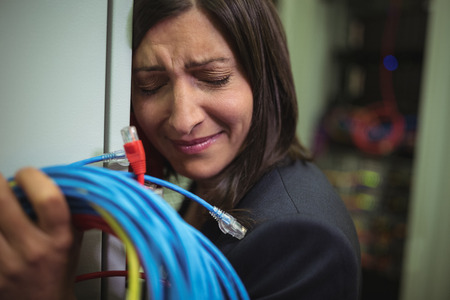 Sad technician leaning on wall in server roomの写真素材