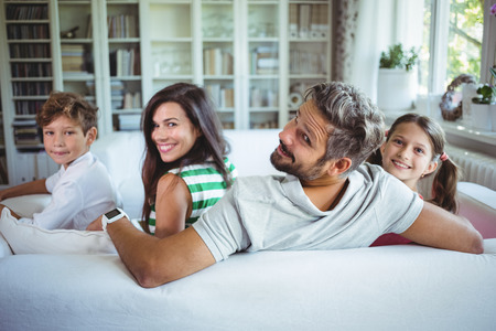 Happy family sitting on sofa at home