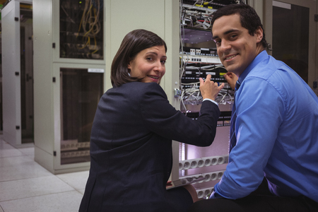 Portrait of technicians analyzing server in server roomの写真素材