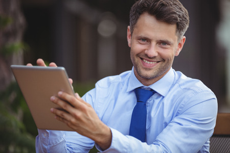 Portrait of businessman using digital tablet at outdoor cafÃ©の写真素材