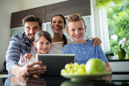 Portrait of happy family using digital tablet at homeの写真素材
