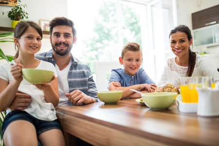 Portrait of family having breakfast at homeの写真素材