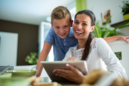 Mother and son using digital tablet in the living room at homeの写真素材
