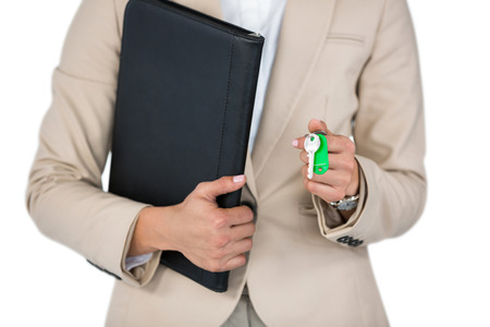 Mid-section of Businesswoman holding a file and key against white backgroundの写真素材