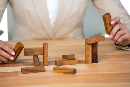 Business man placing wooden block on a towerÂ in officeの写真素材