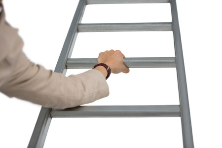 Businesswoman holding ladder against white backgroundの写真素材