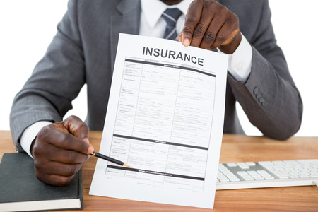 Mid section of businessman showing insurance documentの写真素材