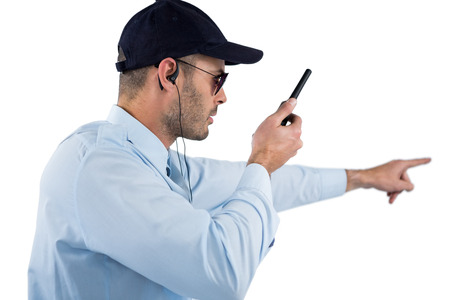 Security officer talking on walkie-talkie against white background