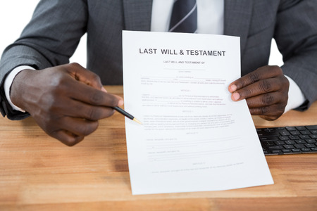 Mid section of businessman showing Last Will & Testament documentの写真素材