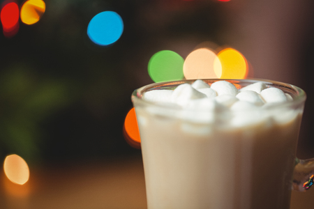 Cup of coffee with marshmallow on wooden table during christmas time