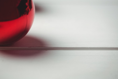 Close-up of red christmas bauble on wooden table