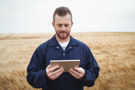 Farmer using digital tablet in the field on a sunny dayの写真素材