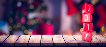Composite image of numbers stack of cubes against defocused of christmas tree lights and fireplaceの写真素材