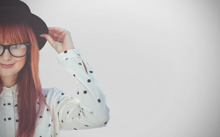 Attractive smiling hipster woman with hat  against white background with vignetteの写真素材