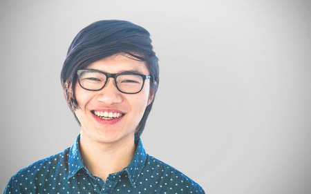 Smiling hipster businessman looking at camera  against white background with vignette