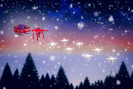High angle view of mini drone pulling Chirstmas sledge against snow falling on fir tree forestの写真素材