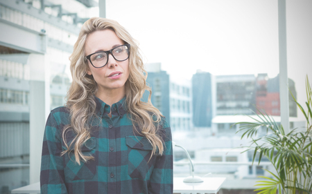 Thinking hipster against working desk in a officeの写真素材
