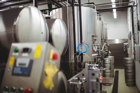 Machinery and kegs in illuminated breweryの写真素材