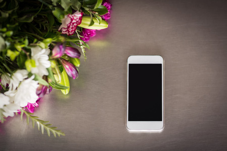 Flowers and mobile phone on the table at florist shop