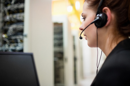 Technician talking on headset in server room
