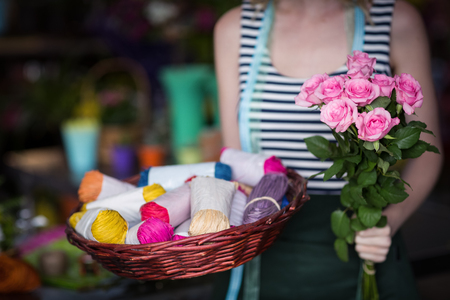 Mid-section of female florist holding bunch of flower in the shopの写真素材