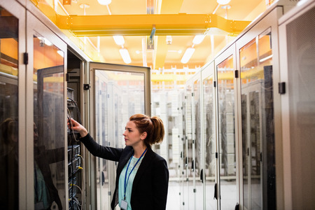 Technician examining server in server room