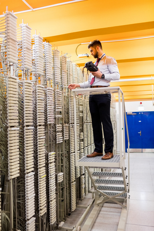Technician using digital cable analyzer in server roomの写真素材