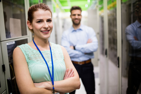 Portrait of technicians standing with arms crossed in a server roomの写真素材