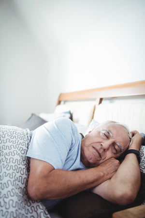 Senior man sleeping on bed at bedroomの写真素材