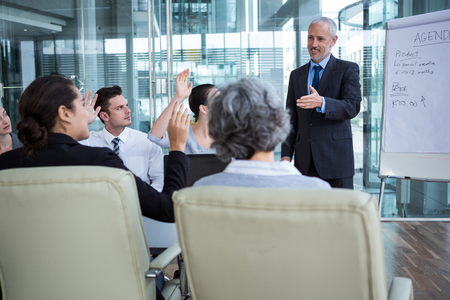 Businessman interacting with coworkers in officeの写真素材