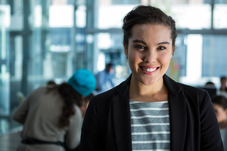 Portrait of smiling businesswoman standing in office