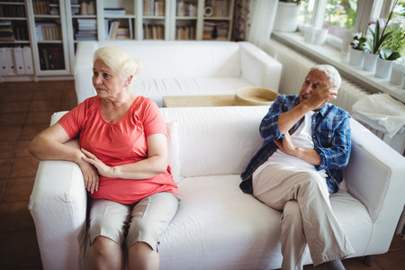 Upset senior couple ignoring each other at homeの写真素材