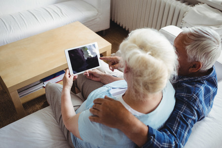Senior couple using digital tablet at home