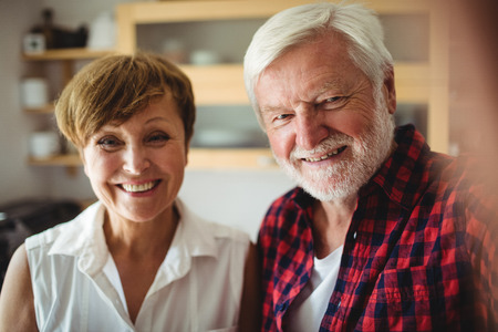 Portrait of senior couple smiling in kitchen at homeの写真素材