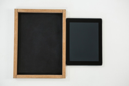 Close-up of digital tablet and slate on white backgroundの写真素材