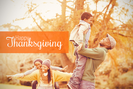 Thanksgiving greeting text against view of a happy young familyの写真素材