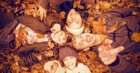 Smiling young family doing a head circles on an autumns day