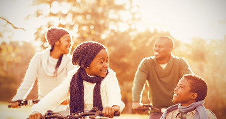 Young smiling family doing a bike ride on an autumns dayの写真素材