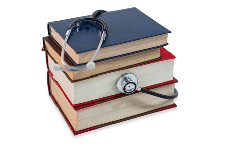 Stethoscope on stack of book against white backgroundの写真素材