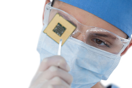 Close-up of female surgeon holding a processor against white background