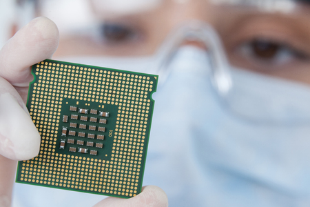 Close-up of female surgeon holding a processor against white backgroundの写真素材