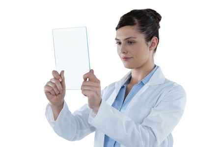 Beautiful female doctor holding digital tablet against white backgroundの写真素材