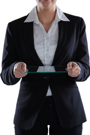 Mid section of businesswoman pretending to use digital tablet against white backgroundの写真素材