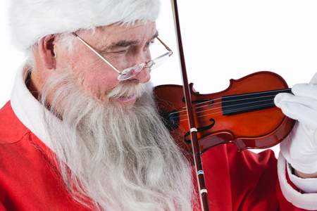 Smiling santa claus playing a violin against white backgroundの写真素材