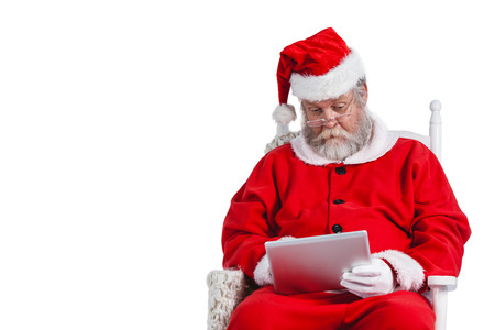 Santa claus using digital tablet against white backgroundの写真素材
