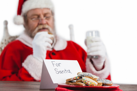 Close-up of cookies on table with santa claus in backgroundの写真素材