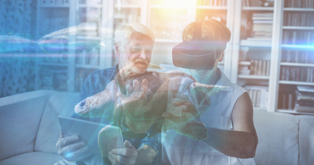 Sea turtle swimming with fish in tank against senior couple using digital tablet and virtual reality headsetの写真素材