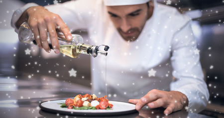 Snow against handsome chef pouring olive oil on mealの写真素材
