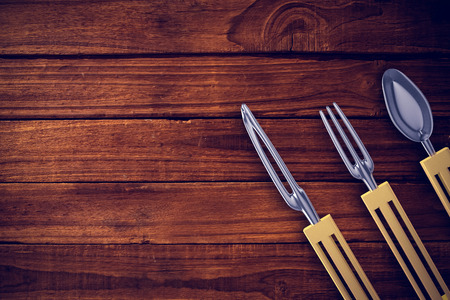 Plastic knife, fork and spoon against overhead of wooden planks